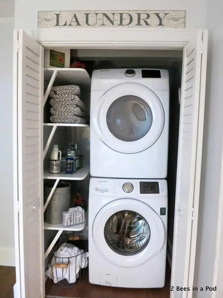 open shelves with laundry supplies next to stacked washer and dryer in a tiny laundry room
