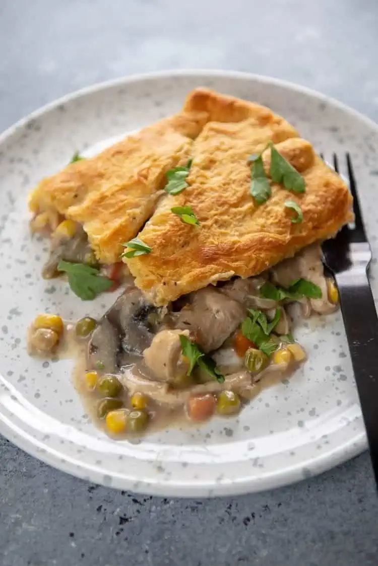 slow cooker chicken pot pie on a plate sprinkled with parsley