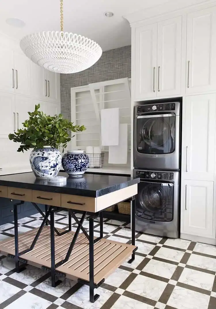 stacked stainless steel washer and dryer in white cabinets in a coastal contemporary house