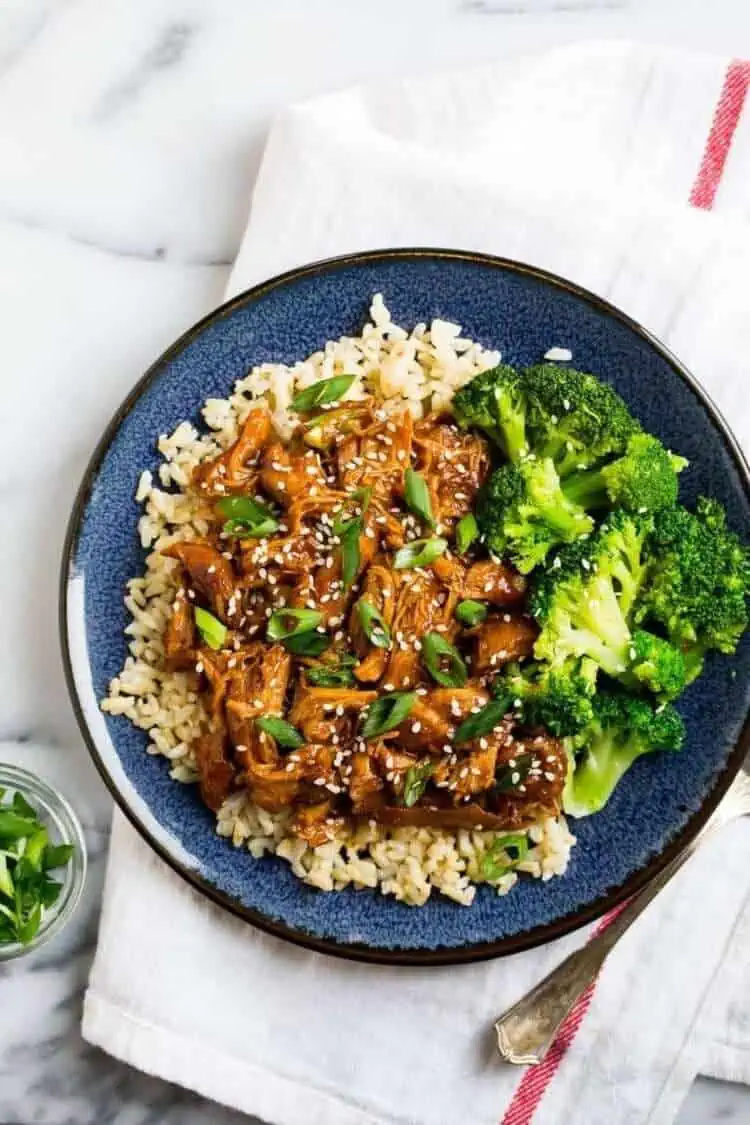 Slow Cooker Honey Garlic Chicken and Veggies on rice on a blue plate