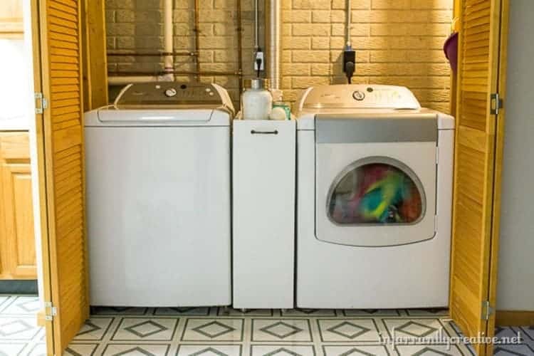 17 - closet with yellow folding doors turned into laundry room with white dryer and washer and a slim rolling cart between them