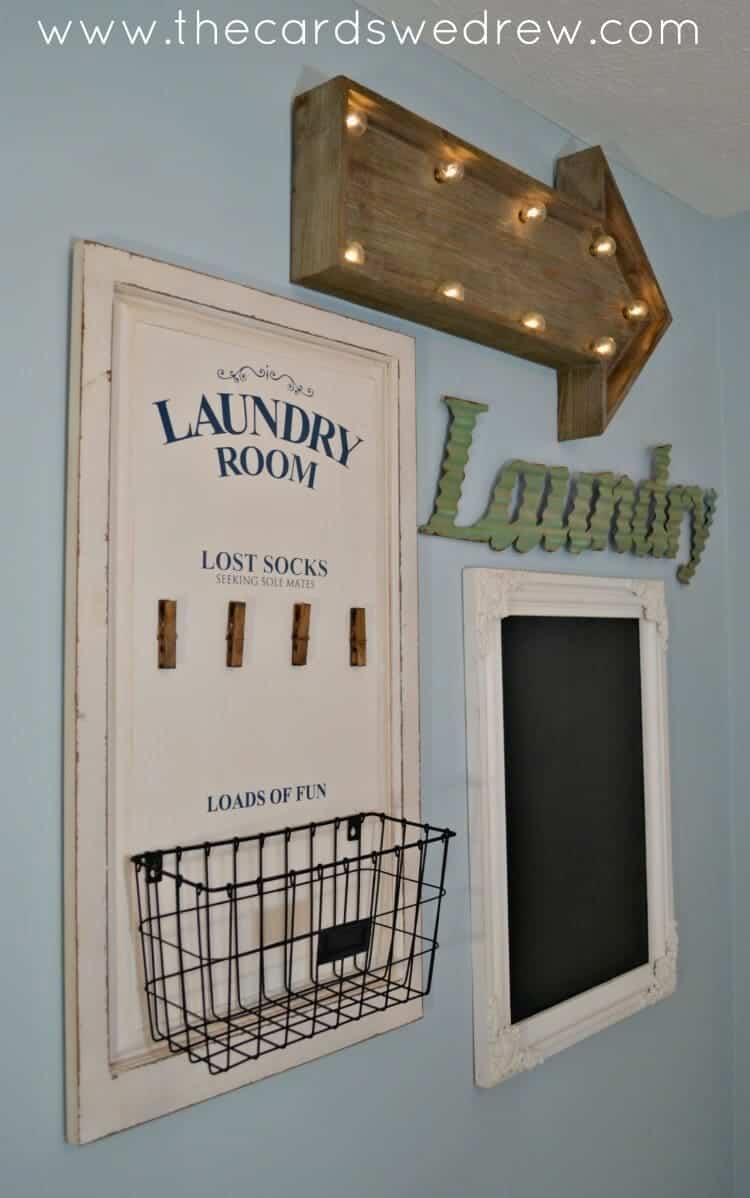 blue wall in costal style with a white laundry room sign, a lost socks sign with clothespins under it and a wire basket attached