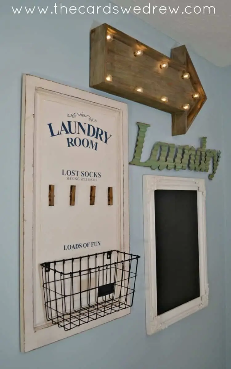 blue wall in costal style with a white laundry room sign, a lost socks sign with clothespins under it and a wire basket attached