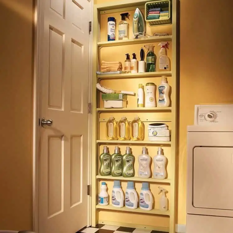 behind the door slim storage with shelves with different laundry supplies, iron, cleaning burshes, dryer sheets, etc.