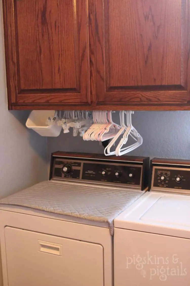 Under Cabinet Mounted rod for hangers, baskets, and other supplies in a small laundry room
