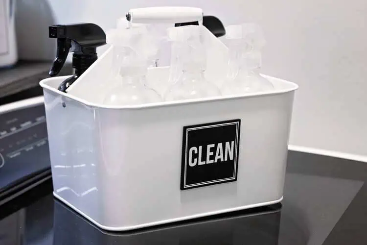 cleaning caddy white plastic container with handle and a clean sign and filled with bottles and supplies to organize in your laundry room