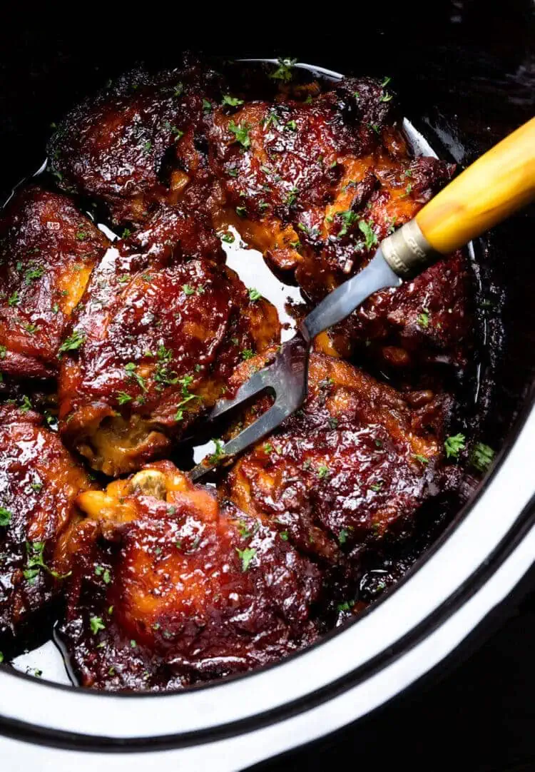crock-pot chicken thighs in pot poked with fork