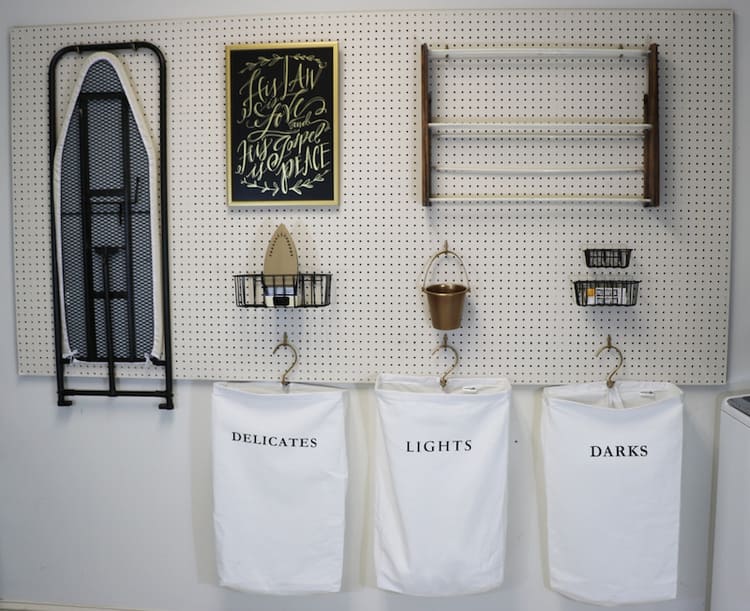  Small Laundry Room Organization with a DIY Peg Board Wall and hanged ironing board, wire baskets, laundry bags for delicates, lights and darks, laundry supplies