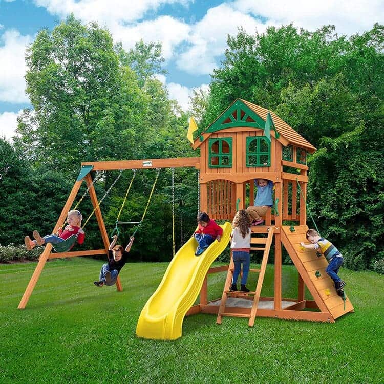 backyard swing set, tower, with slide and a climbing wall with rope and sandbox, wooden, metal and plastic with green, yellow and brown color, on a green landscape