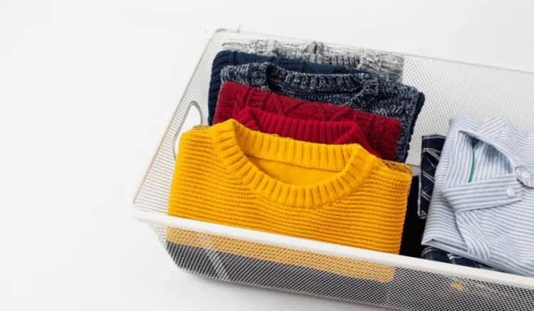 Sweaters folded in a wire basket