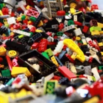 Large plastic bin filled with many lego bricks and pieces, in different colors
