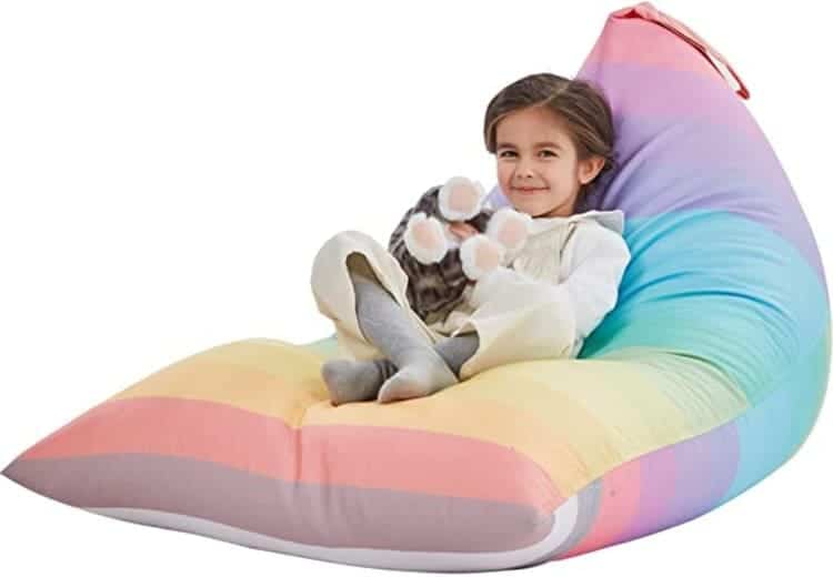 Stuffed toys bean bag rainbow color with a girl sitting on it