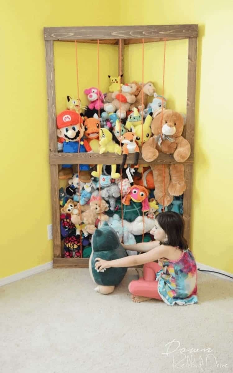 DIY Corner stuffed animals zoo storage to put away all of the stuffed toys and a girl sitting in front with a teddy