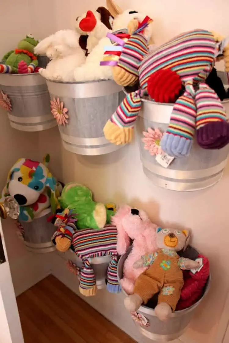 store soft toys in tin buckets mounted on the walls filled with toys