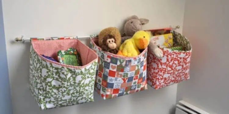 colorful pattern fabric bags hanged on a rod full of toys, stuffed animals and books