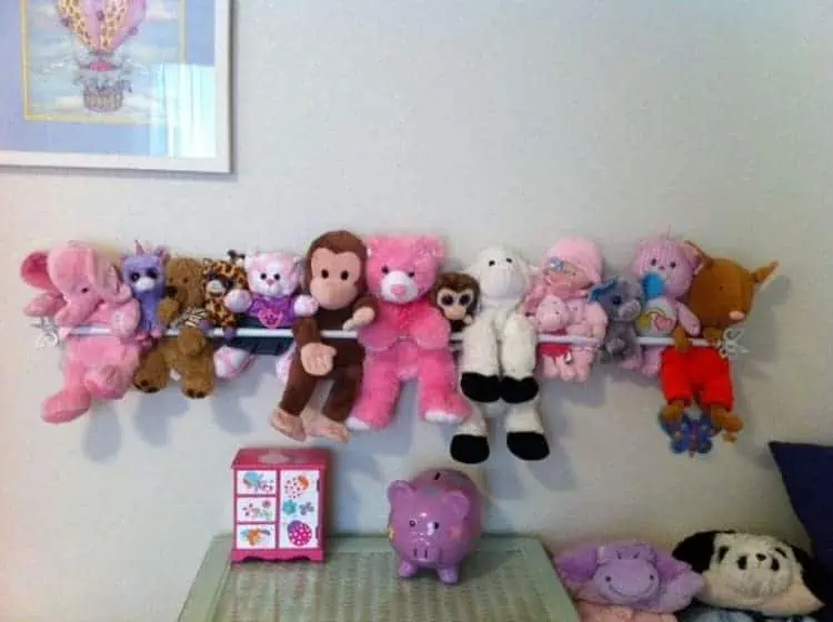 use a tension rod to organize stuffed animals in your children rooms