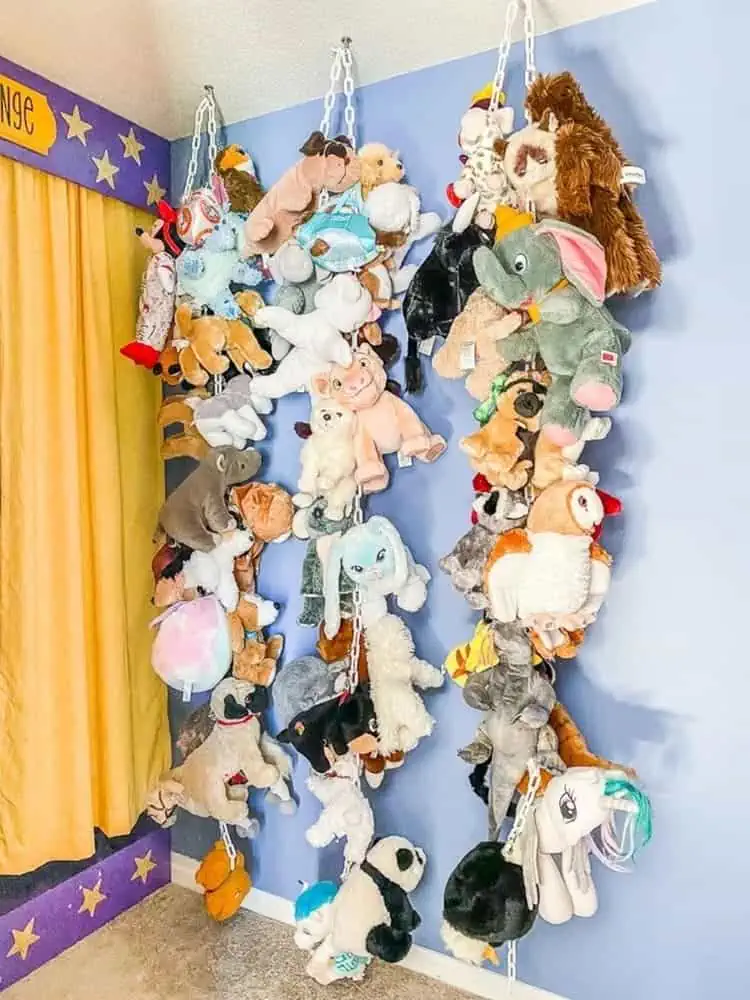 stuffed animal storage with plastic chains hanging from the ceiling in a kids room