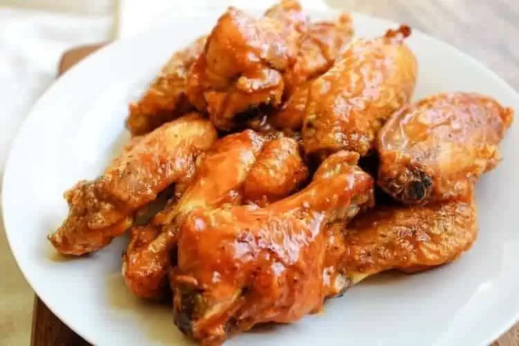 Air Fryer Chicken Wings with Buffalo Sauce served on a white plate