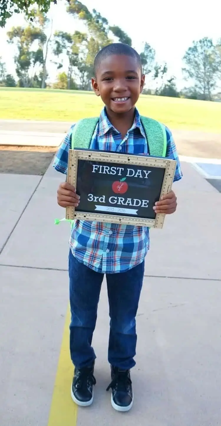 Boy holding DIY first day of school sign for 3rd grade free back-to-school sign printable