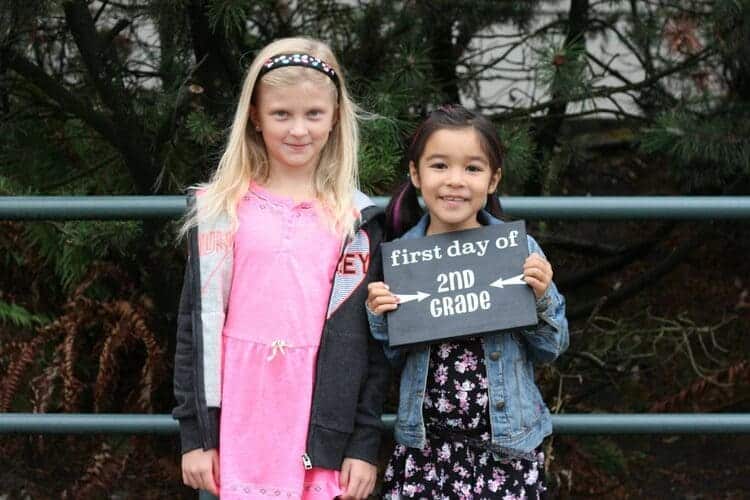 first day of school sign for second grade two girls on the photo