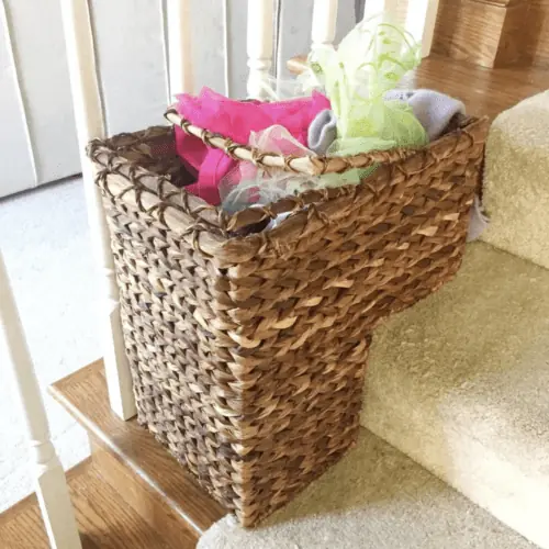 basket on stairs with clothing in it