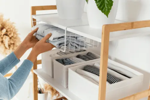 woman putting away folded shirts