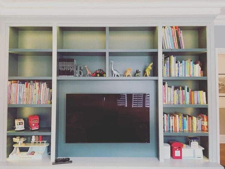 built-in cupboards around the tv for additional toy storage in the living room