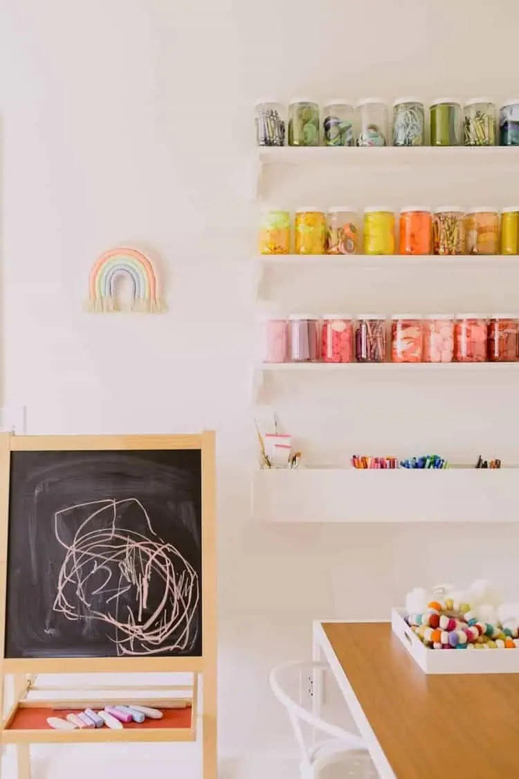 organize art and craft supplies in jars on narrow shelves in a playroom