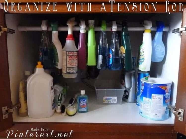 Use Tension Rods Under Your Bathroom Sink to spray bottles and hang supplies