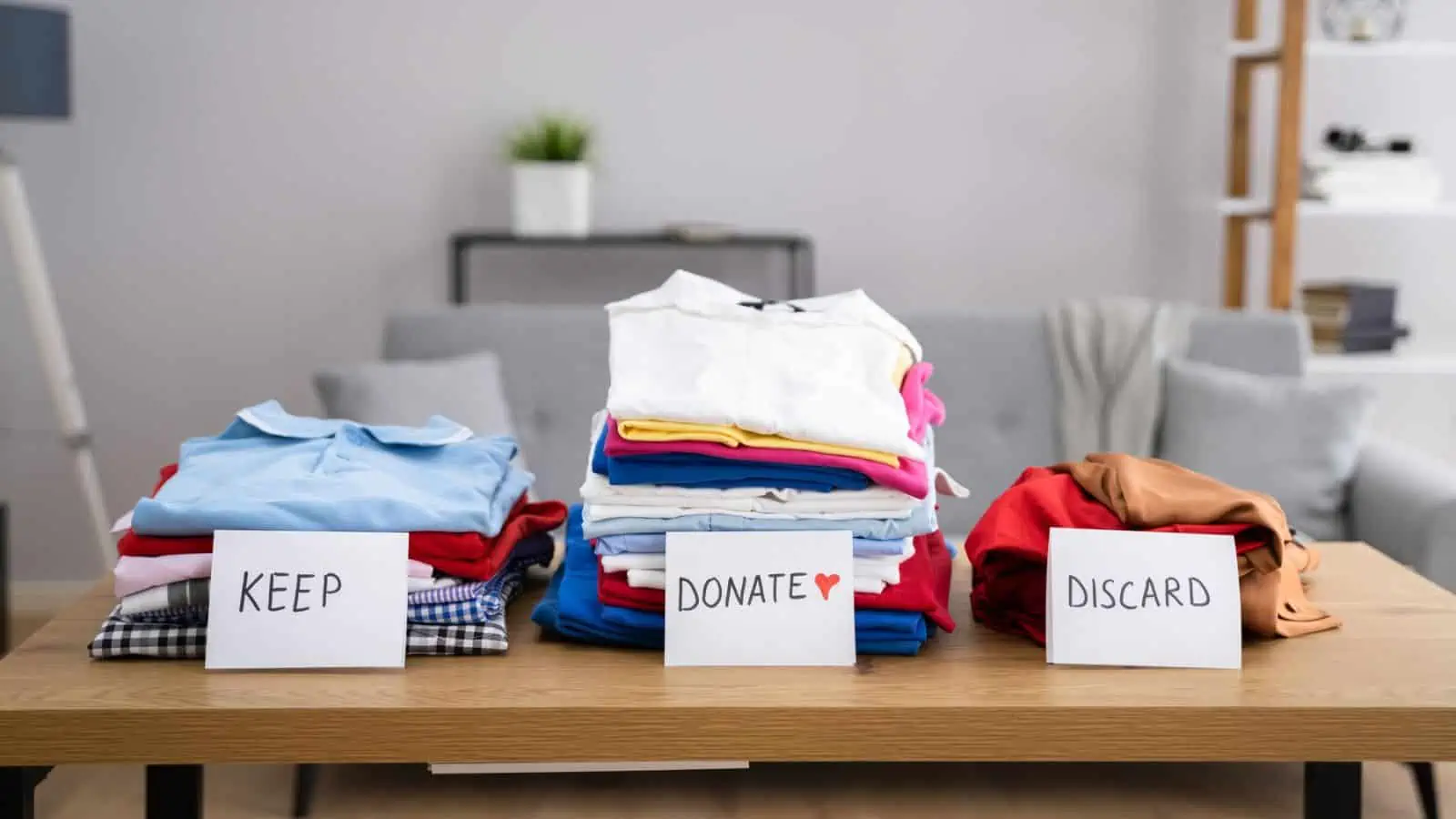 clothes organized in three piles keep donate and discard