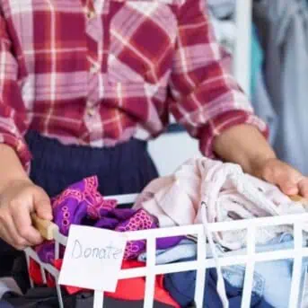 woman sorting clothing into decluttering pile