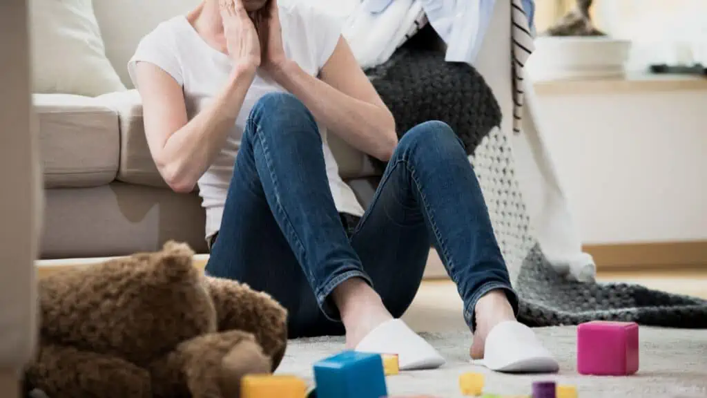 woman sitting on floor surrounded by toys