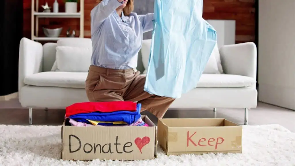 woman sorting clothing into donate and keep piles