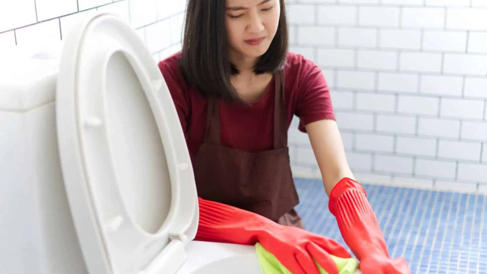 Unhappy Woman cleaning toilet