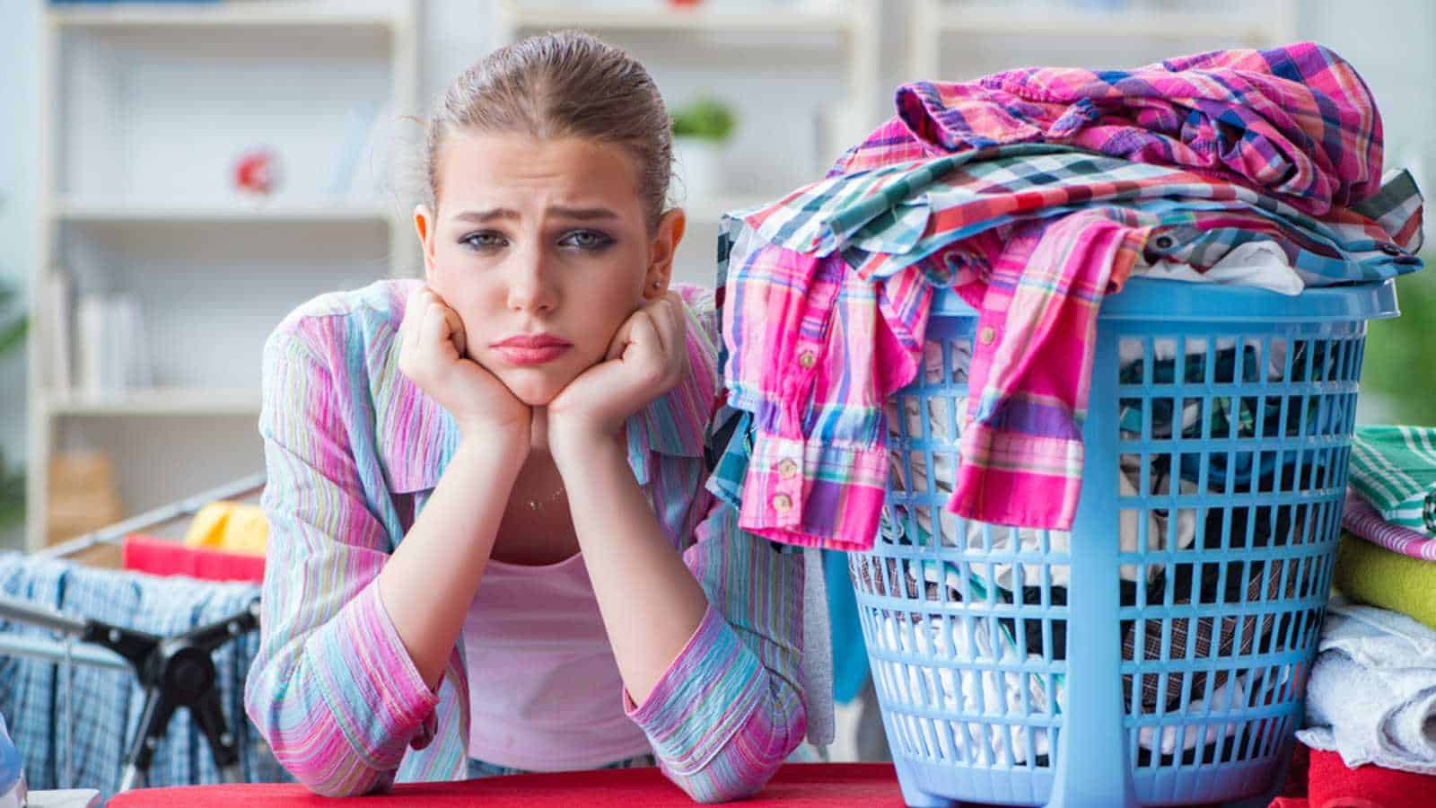 Tired depressed housewife doing laundry