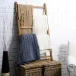 beige gray and white blankets on blanket ladder next to white chair