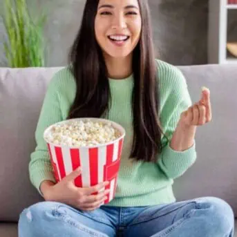 Woman with popcorn watching tv