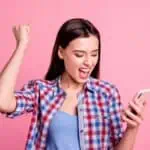 excited woman looking at phone
