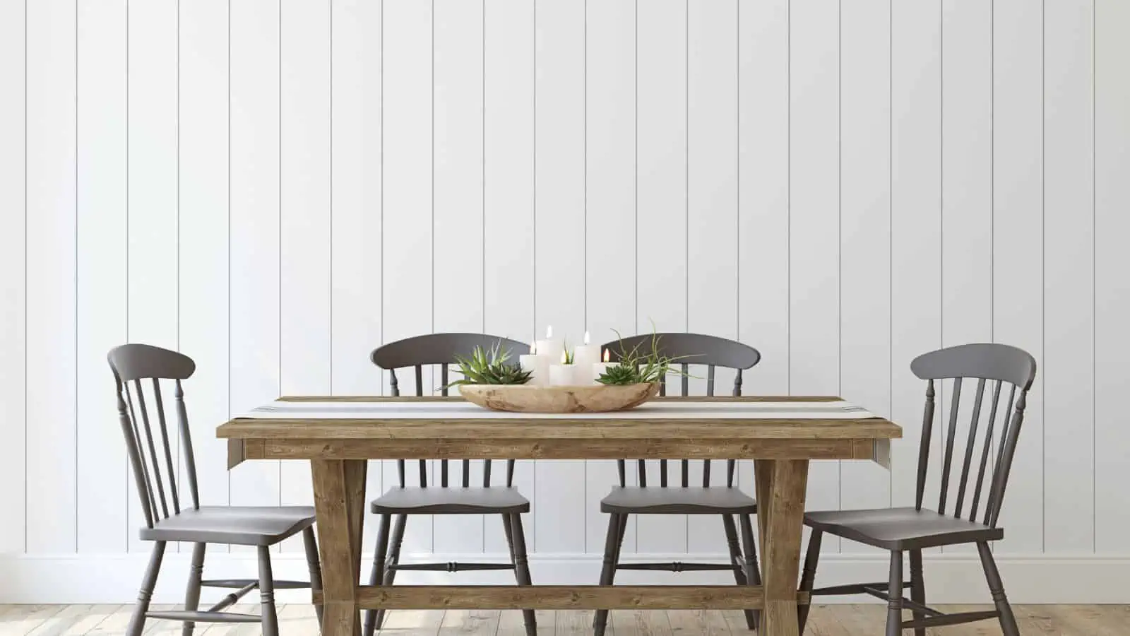 four chairs around a farmhouse table with candles burning on it