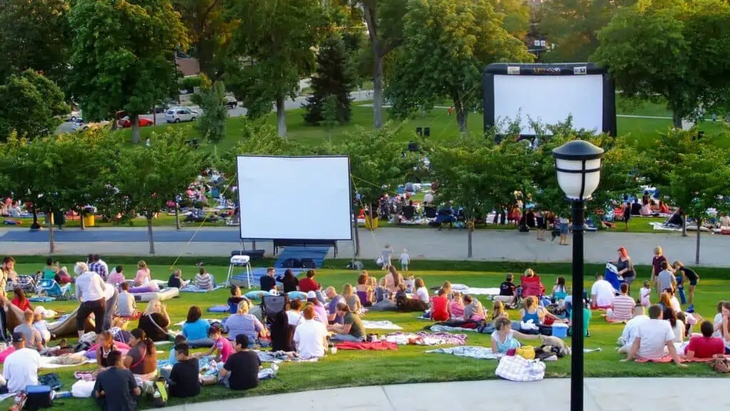 crowd gathering in park to watch movie outside