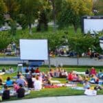 crowd gathering in park to watch movie outside