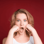 shocked woman with mouth open red background