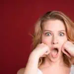 shocked woman with mouth open red background