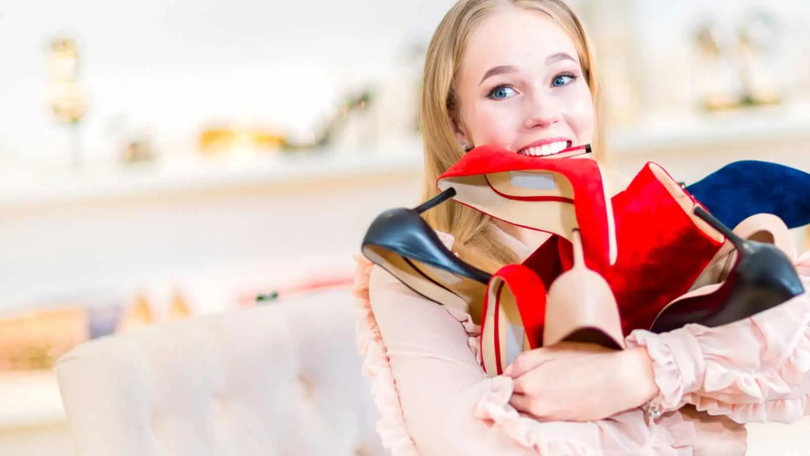 woman carrying shoes with one in her mouth