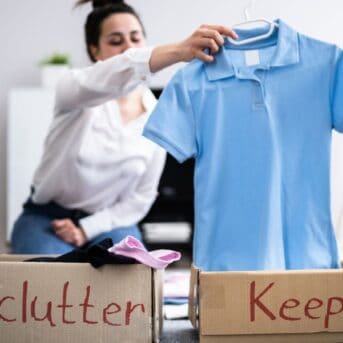 woman holding a blue shirt while decluttering