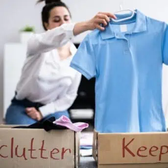 woman holding a blue shirt while decluttering