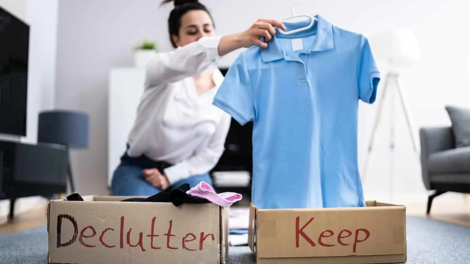 woman holding a blue shirt while decluttering