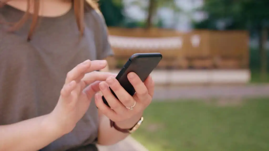 woman outside scrolling on her phone