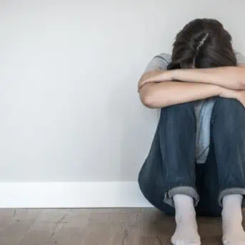 woman sitting on the floor with with head down