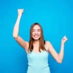 Portrait of delighted cute attractive student lady feeling good great perfect of lottery competition excited raising fists closed eyes wearing light pastel clothes isolated on azure background